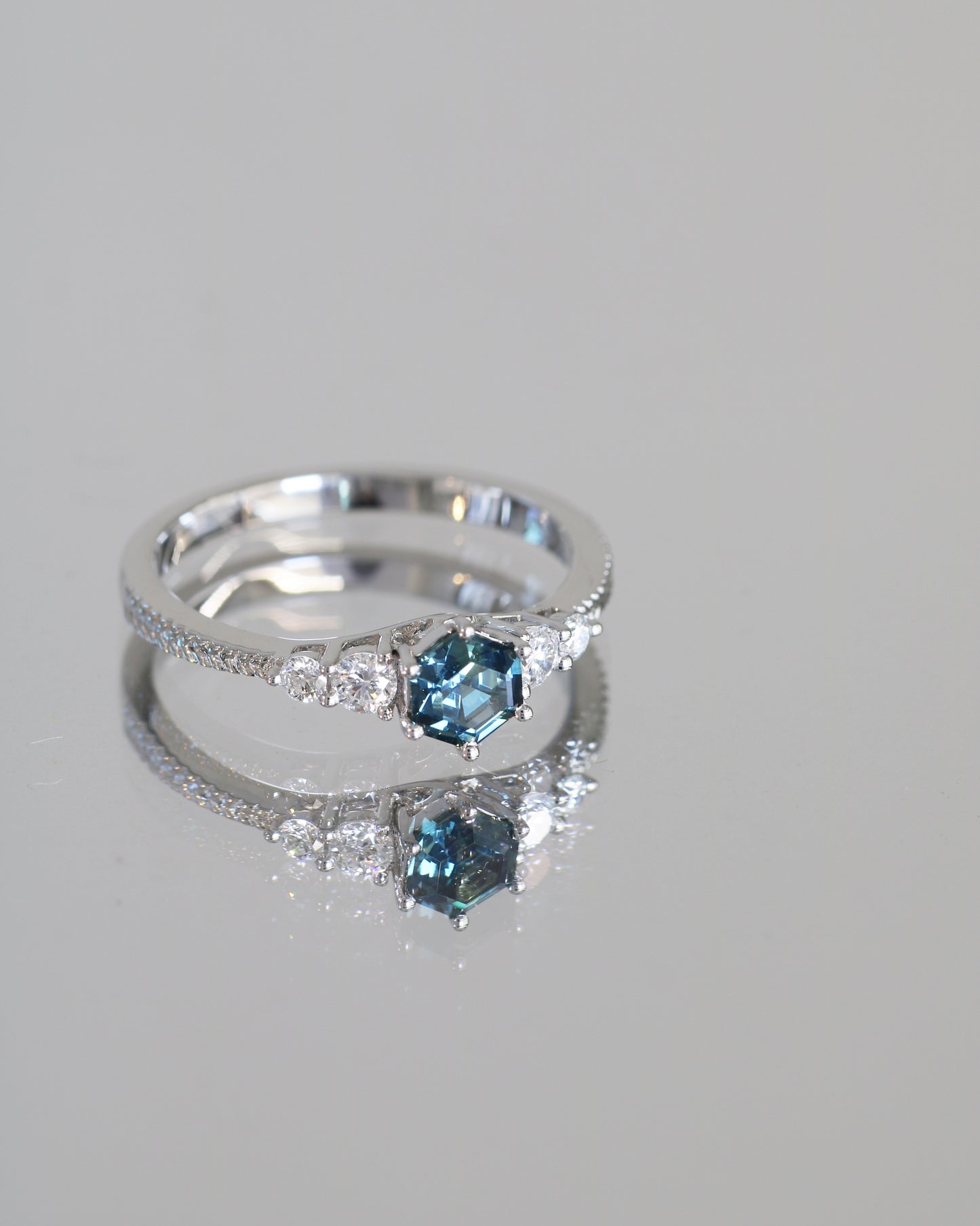 18k white gold blue green teal sapphire ring on a gray background