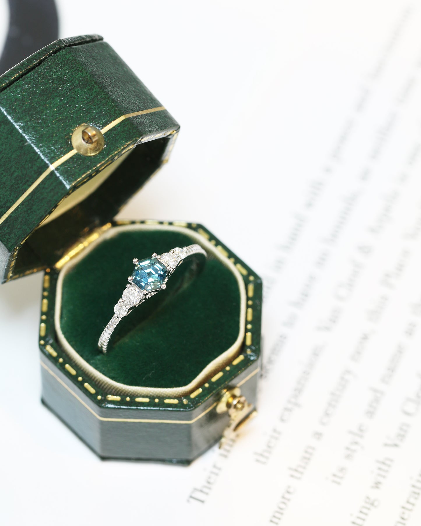 18k white gold blue green teal sapphire ring in a green jewelry box on a white background