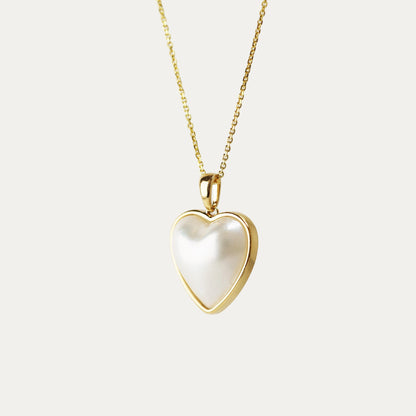 Heart-shaped pendant with gold frame on a light gray background