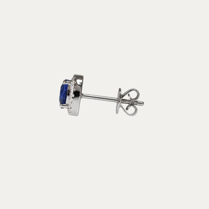 Pair of oval shaped cornflower sapphire earrings on a light gray background