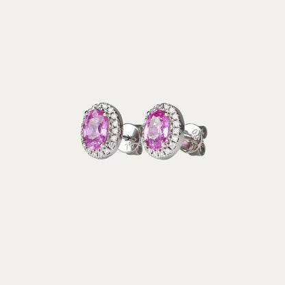 Pair of oval-shaped pink sapphire halo diamond earrings on a gray background