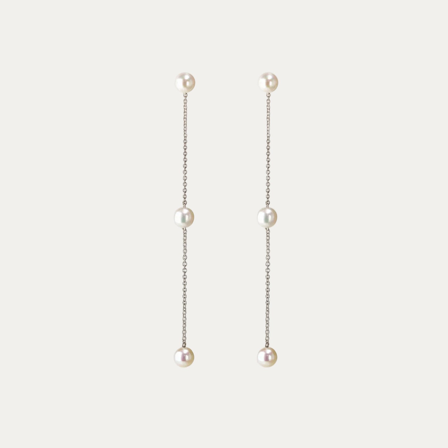 Pearl drop earrings on a light gray background