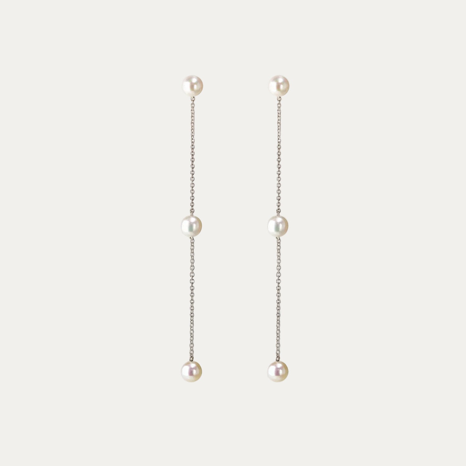 Pearl drop earrings on a light gray background