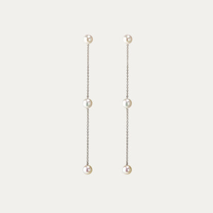 Pearl drop earrings on a light gray background