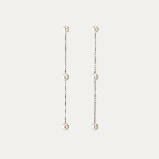 Pearl drop earrings on a light gray background