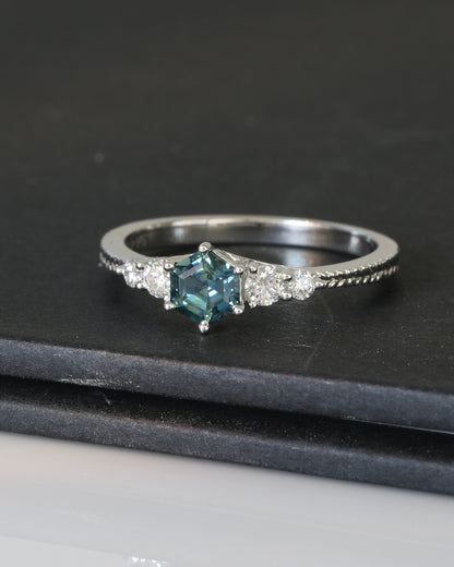 18k white gold blue green teal sapphire ring on a dark surface