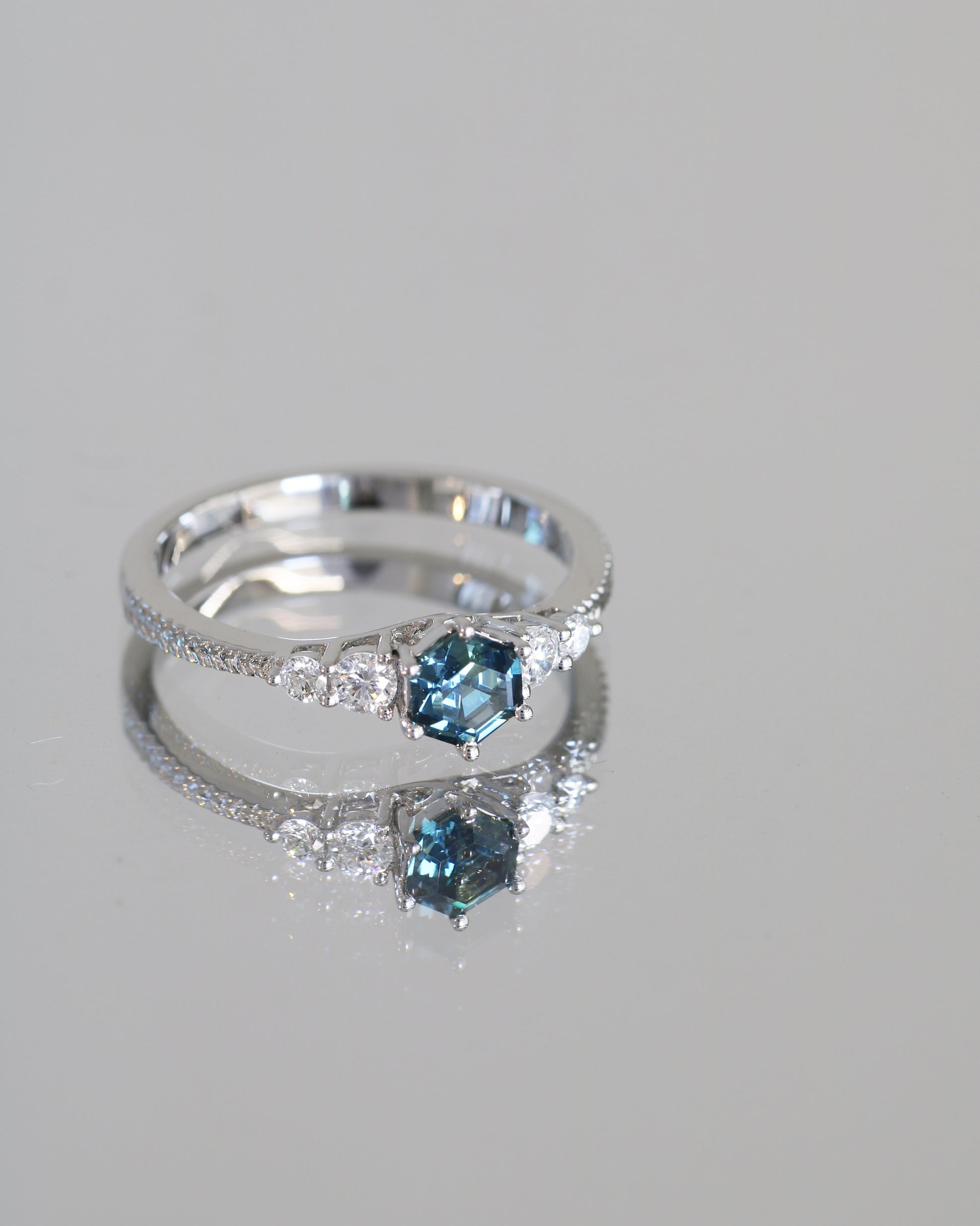 18k white gold blue green teal sapphire ring on a gray background