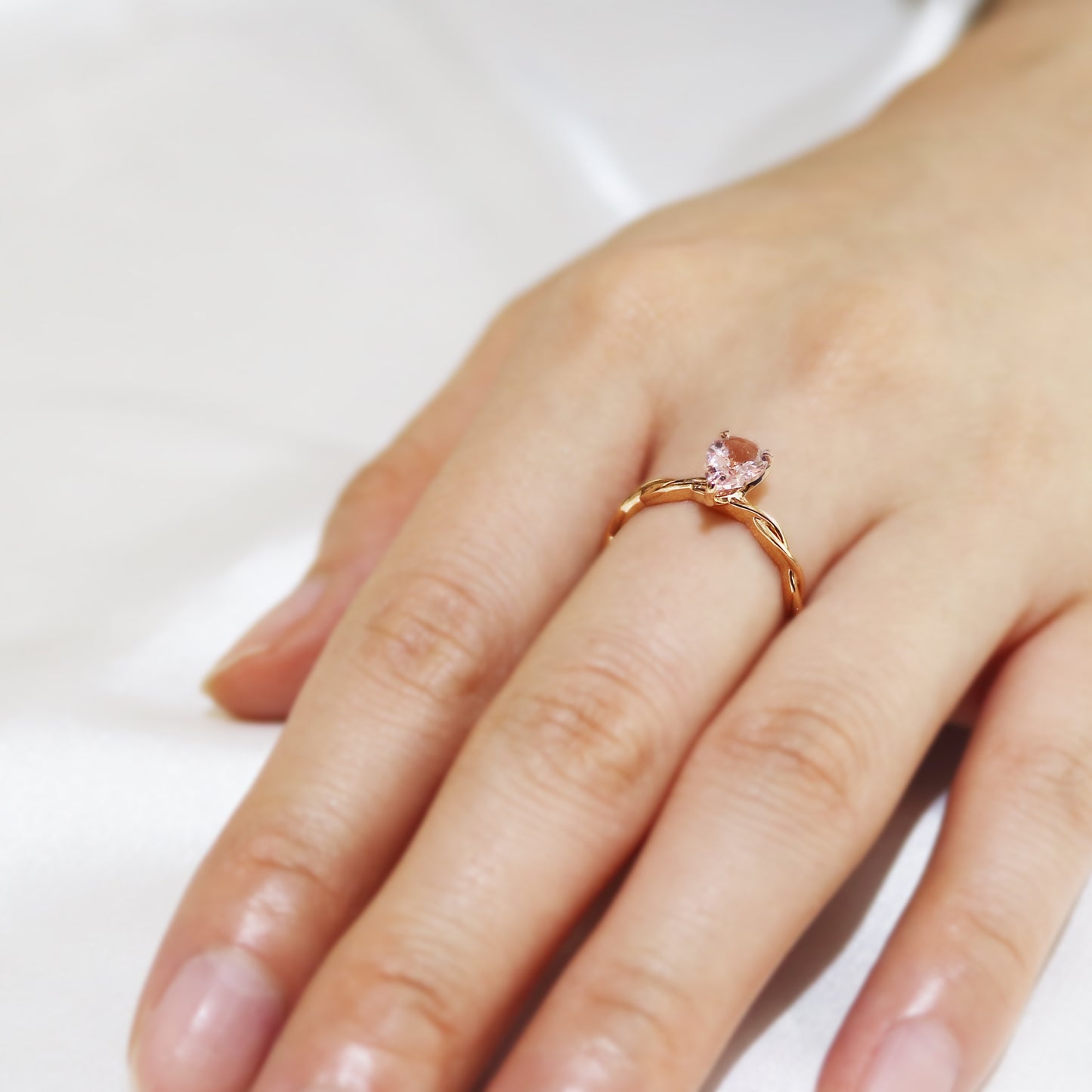 玫瑰金梨形粉紅摩根石鑽石戒指在中指上 Rose Gold Pear-shaped Morganite Diamond Ring on middle finger